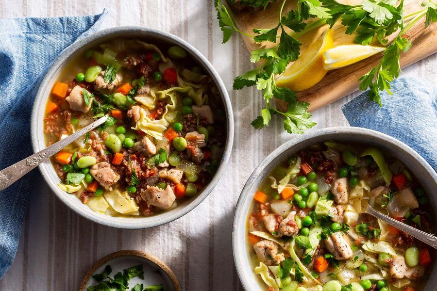 Hearty chicken and red rice soup with limas, cabbage, and sweet peas