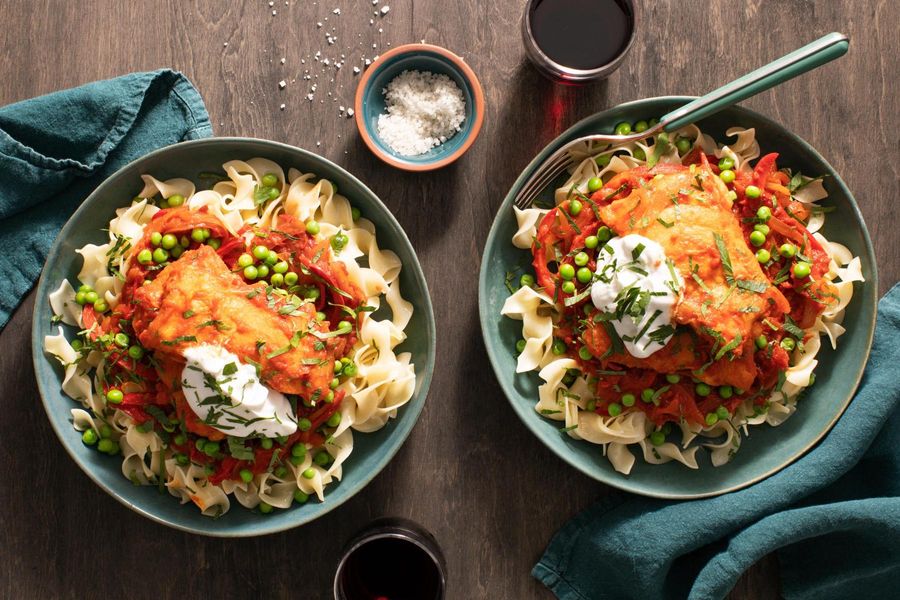 Hungarian chicken paprikash with bell pepper and peas over egg noodles