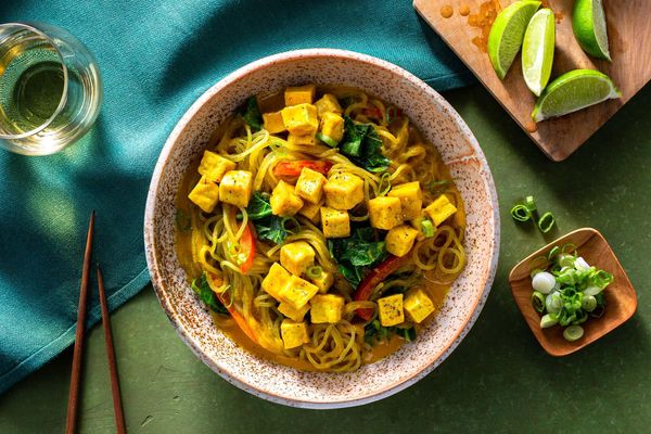 Chicken curry noodle bowls with broccoli leaves and bell pepper