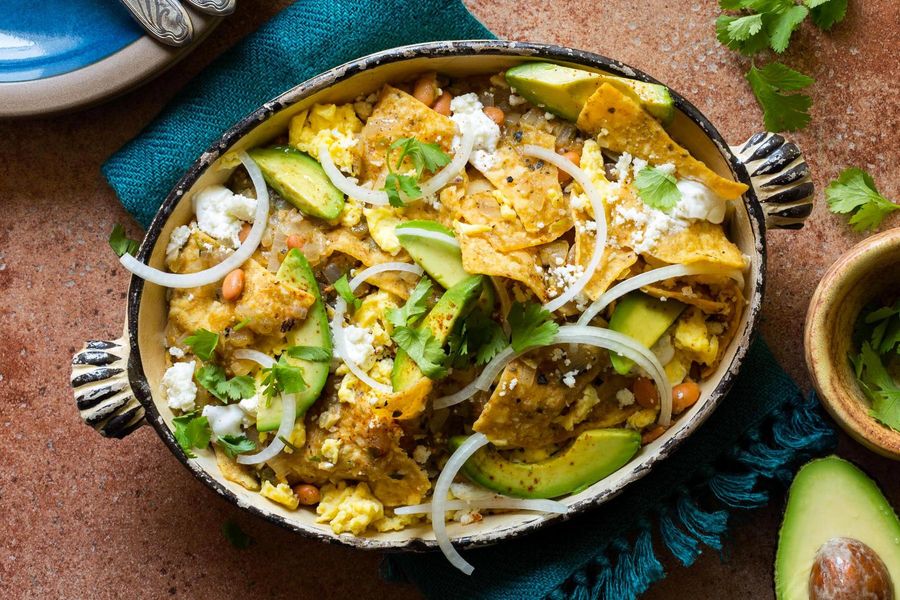 Chilaquiles verdes with soft-scrambled eggs, avocado, and queso fresco