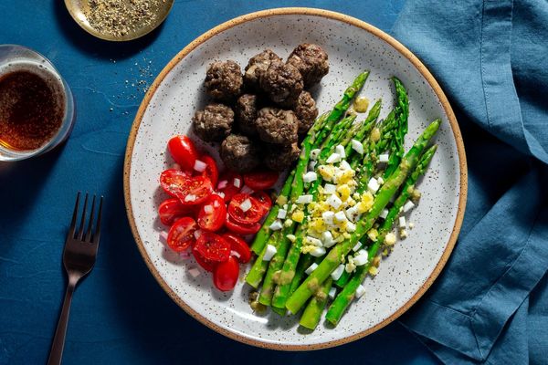 Chicken meatballs with tomato salad and asparagus mimosa