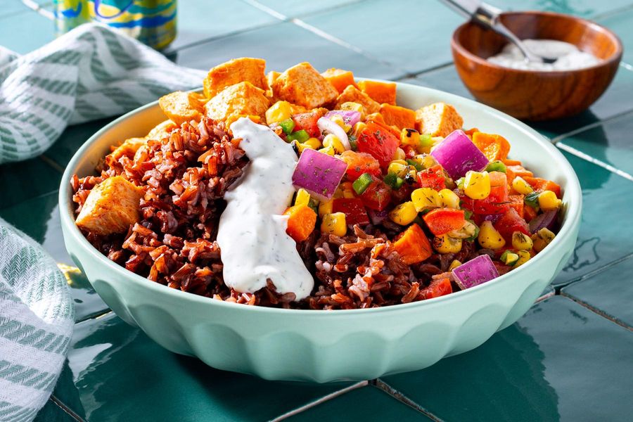 Red rice bowl with chicken, sweet potatoes, and corn jalapeño salad