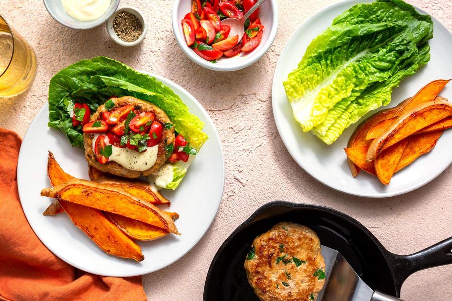 Lettuce-wrapped turkey burgers with tomato relish and sweet potato fries