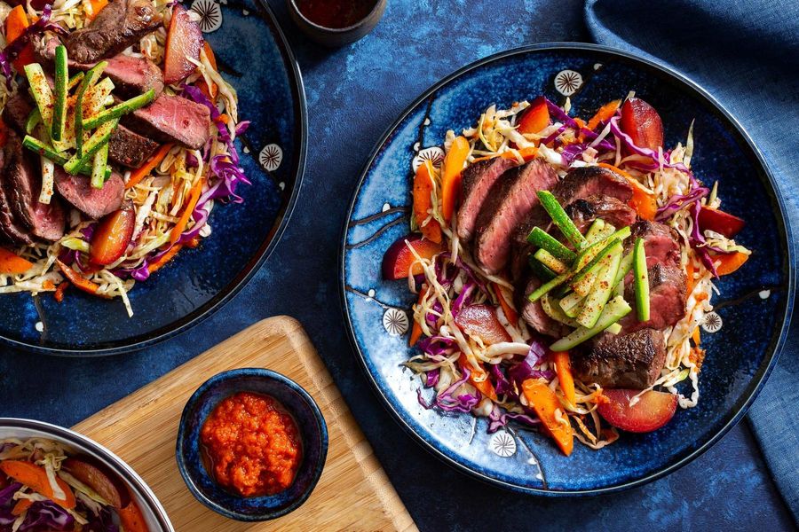 Seared steak over cabbage-plum salad with kimchi vinaigrette