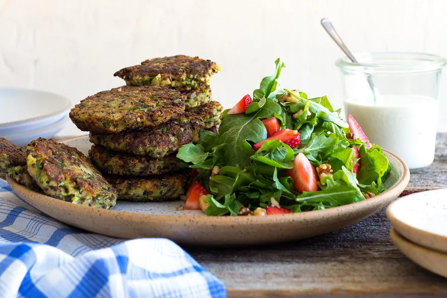 Quinoa fritters with tahini-yogurt sauce and strawberry-arugula salad