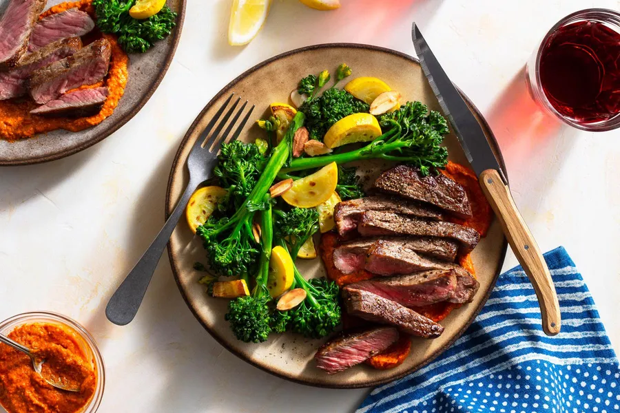 Steaks and romesco with baby broccoli, summer squash, and almonds