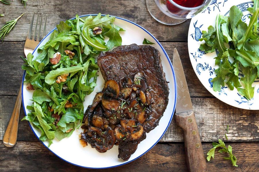 Mushroom-smothered steaks with arugula-walnut salad