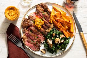 Black Angus rib-eyes with herbed ghee, sweet potato frites, and kale