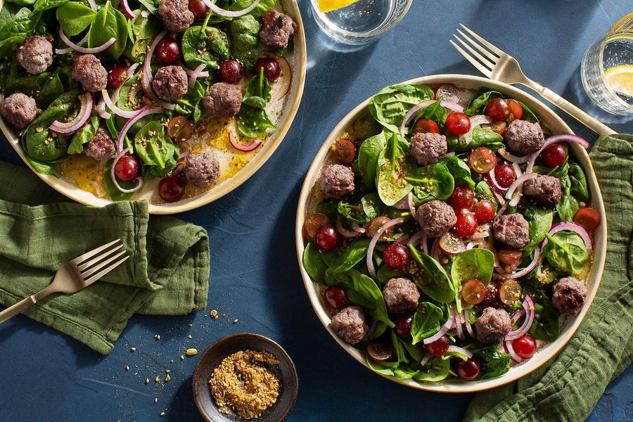 Kefta-spiced meatballs with spinach-grape salad and pumpkin seed dukkah