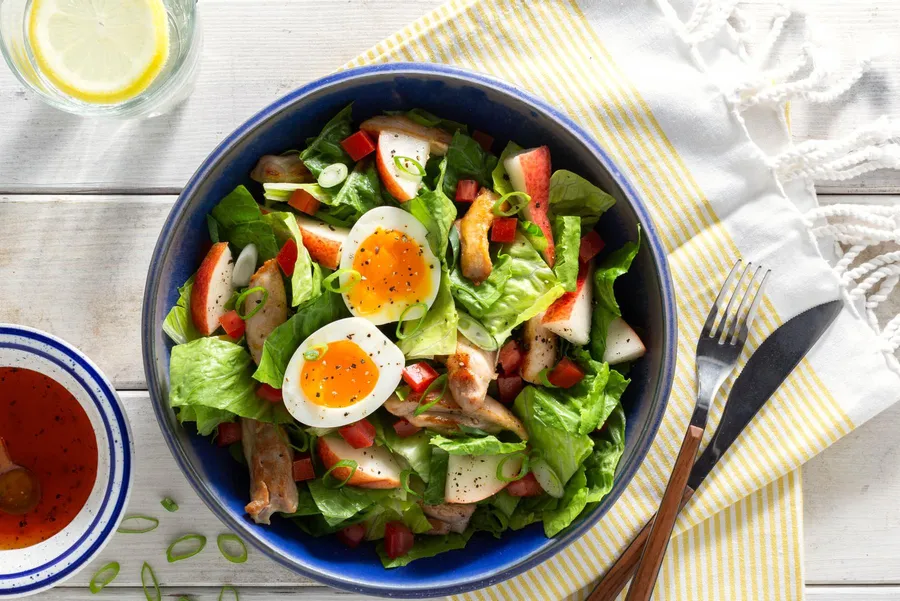 Green salad with chicken, pear, and soft-cooked eggs
