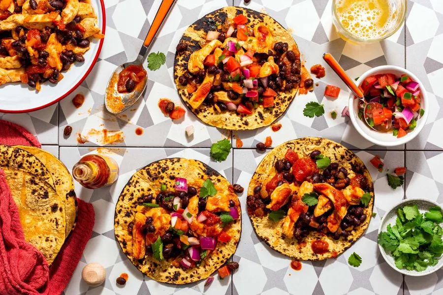Spicy tinga tacos with black beans and pico de gallo