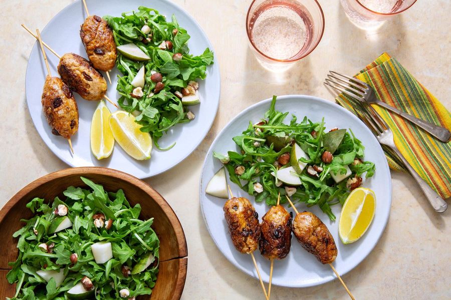 Greek skewers with arugula-pear salad and hazelnuts
