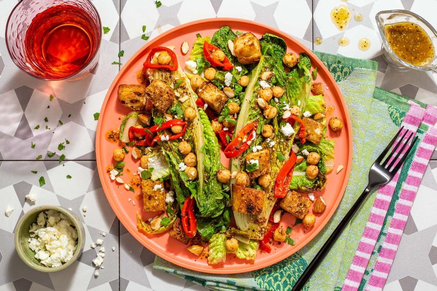 Seared romaine salad with spiced chickpeas, roasted peppers, and almonds