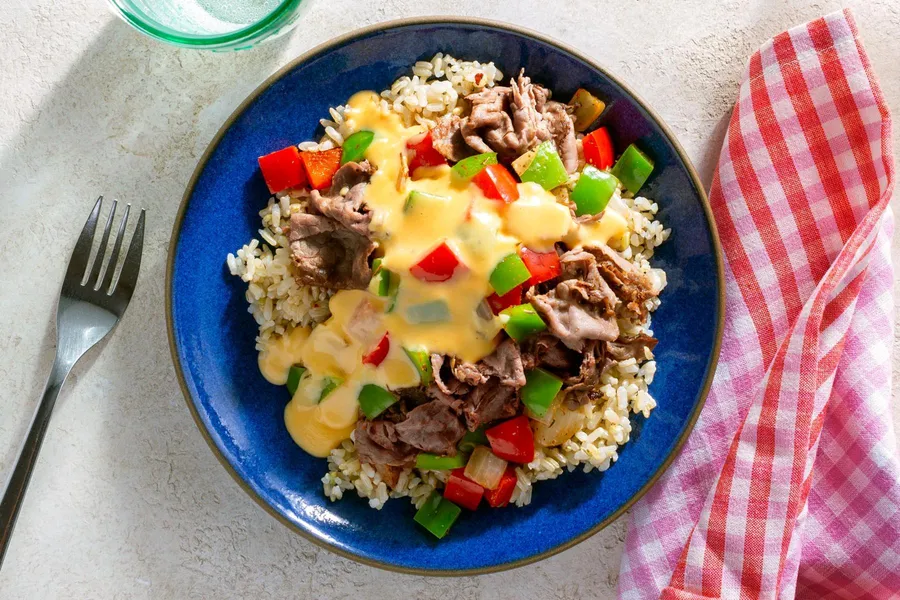 Philly-style steak and peppers with cheese sauce over brown rice