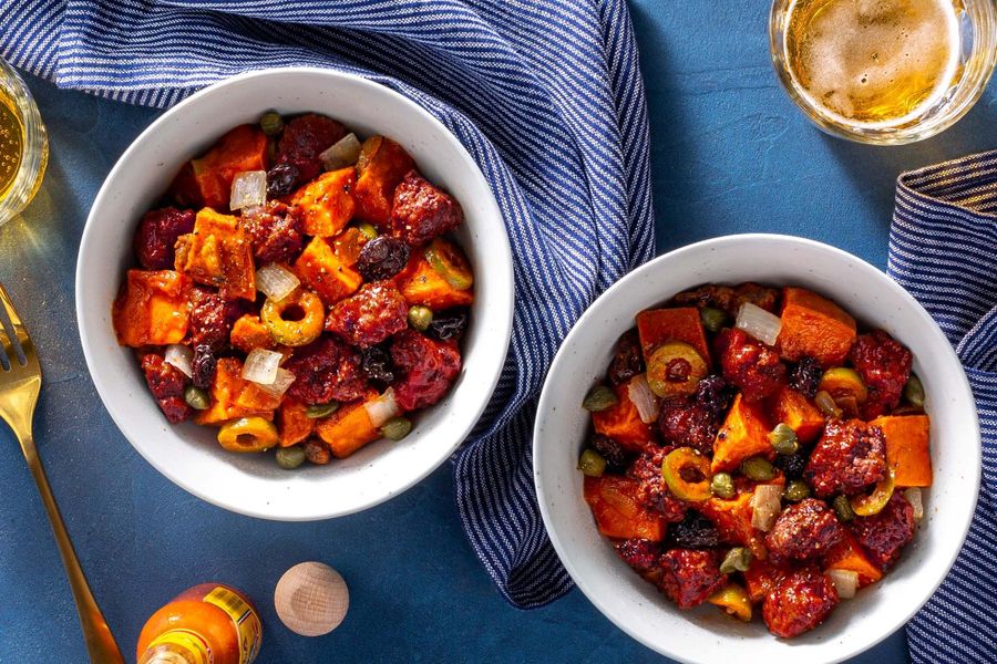 Picadillo stew with capers and raisins over roasted sweet potato