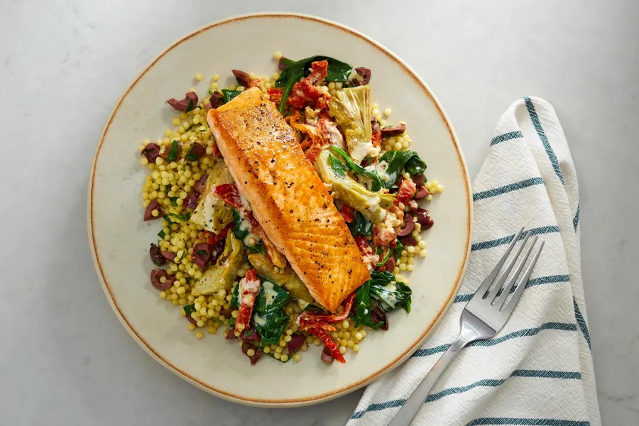 Salmon with sun-dried tomatoes, artichokes, and pearled couscous