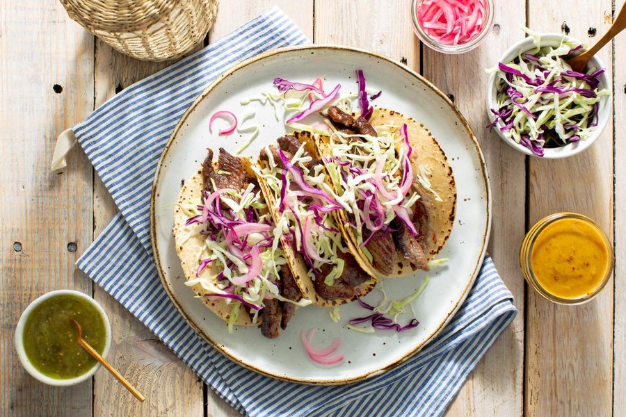 Mojo tacos with shredded cabbage, pickled onions, and salsa verde