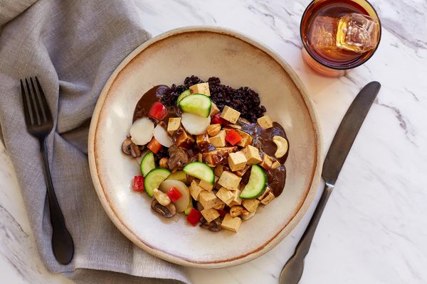 Kung pao tofu bowl with black rice, roasted vegetables, and cashews