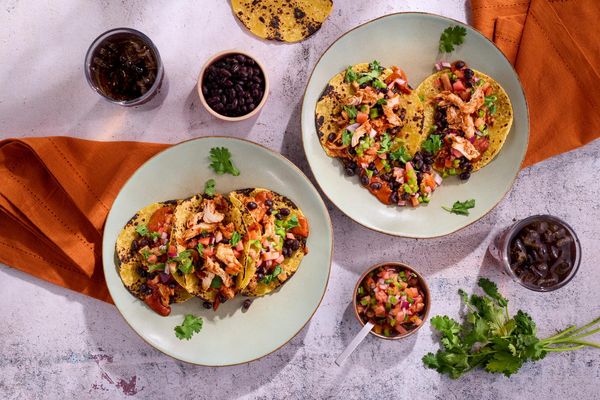 Spicy chicken tinga tacos with black beans and pico de gallo