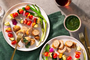 Chicken sausages with vegetable skewers and spicy green harissa