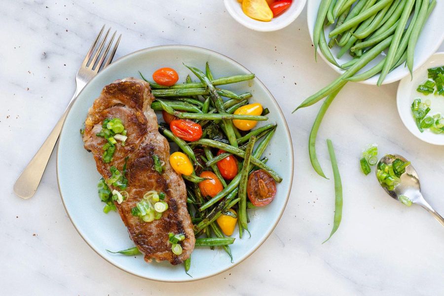 Steaks with blistered green beans and tomatoes