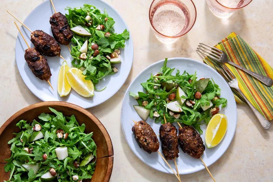 Greek skewers with arugula-pear salad and hazelnuts