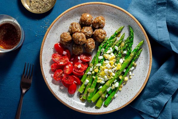 Chicken meatballs with tomato salad and asparagus mimosa